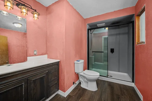 a bathroom with a sink a toilet a shower and a mirror