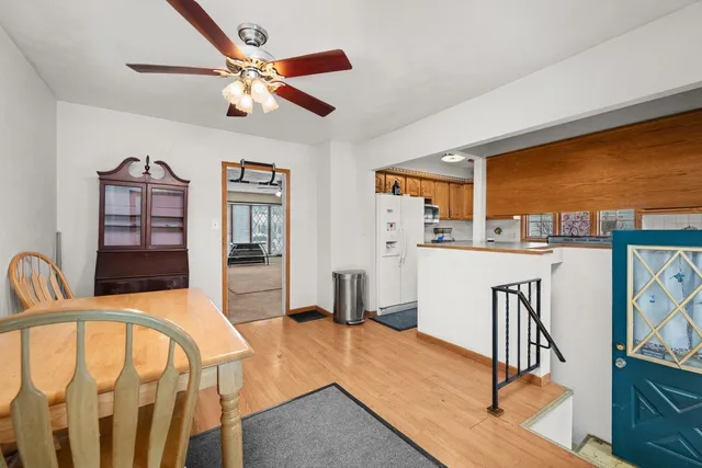 a living room with stainless steel appliances furniture a fireplace and a large window