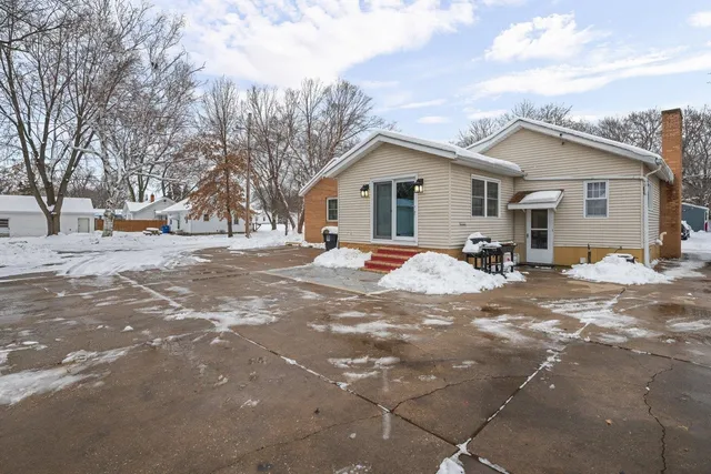 a view of a house with a yard covered in snow