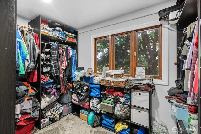 a view of walk in closet with clothes and shoes