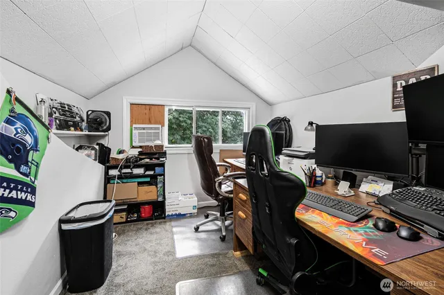 a view of a workspace with furniture and a window