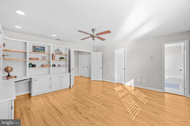 an empty room with closet and a chandelier fan