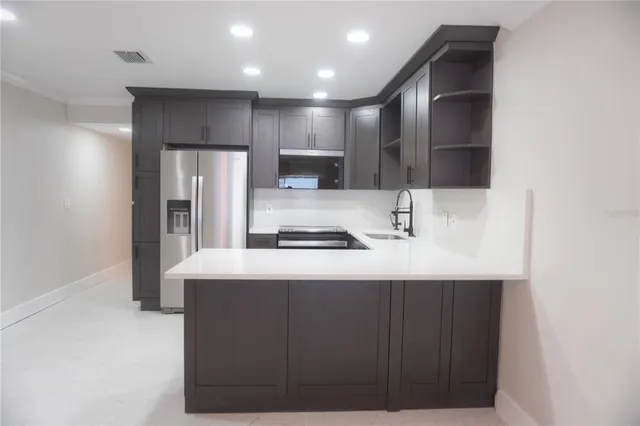 a kitchen with kitchen island a sink stainless steel appliances and cabinets