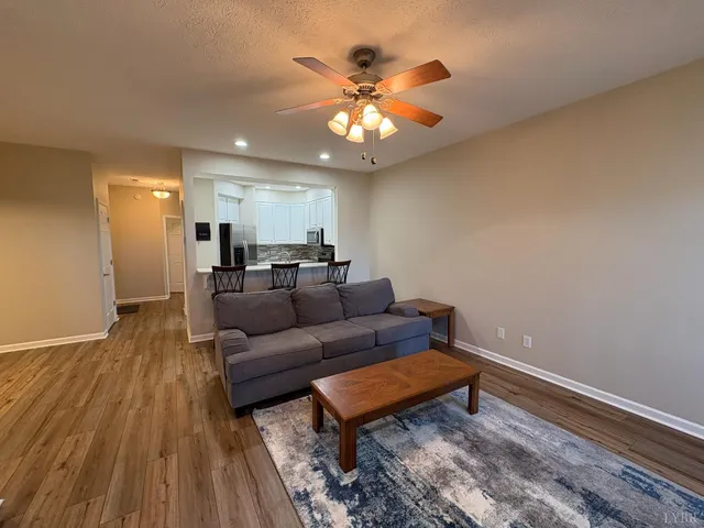 a living room with furniture and a wooden floor