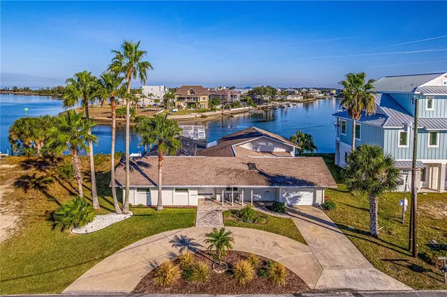an aerial view of a house with a swimming pool and outdoor seating