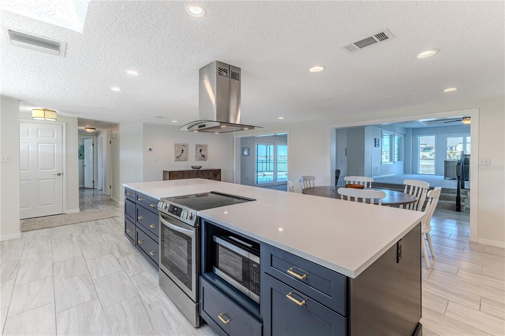 3409 Gulf Winds Circle Hernando Beach, FL 34607 - Photo 15 of 84 a kitchen with a stove a refrigerator a sink dishwasher with a dining table and chairs