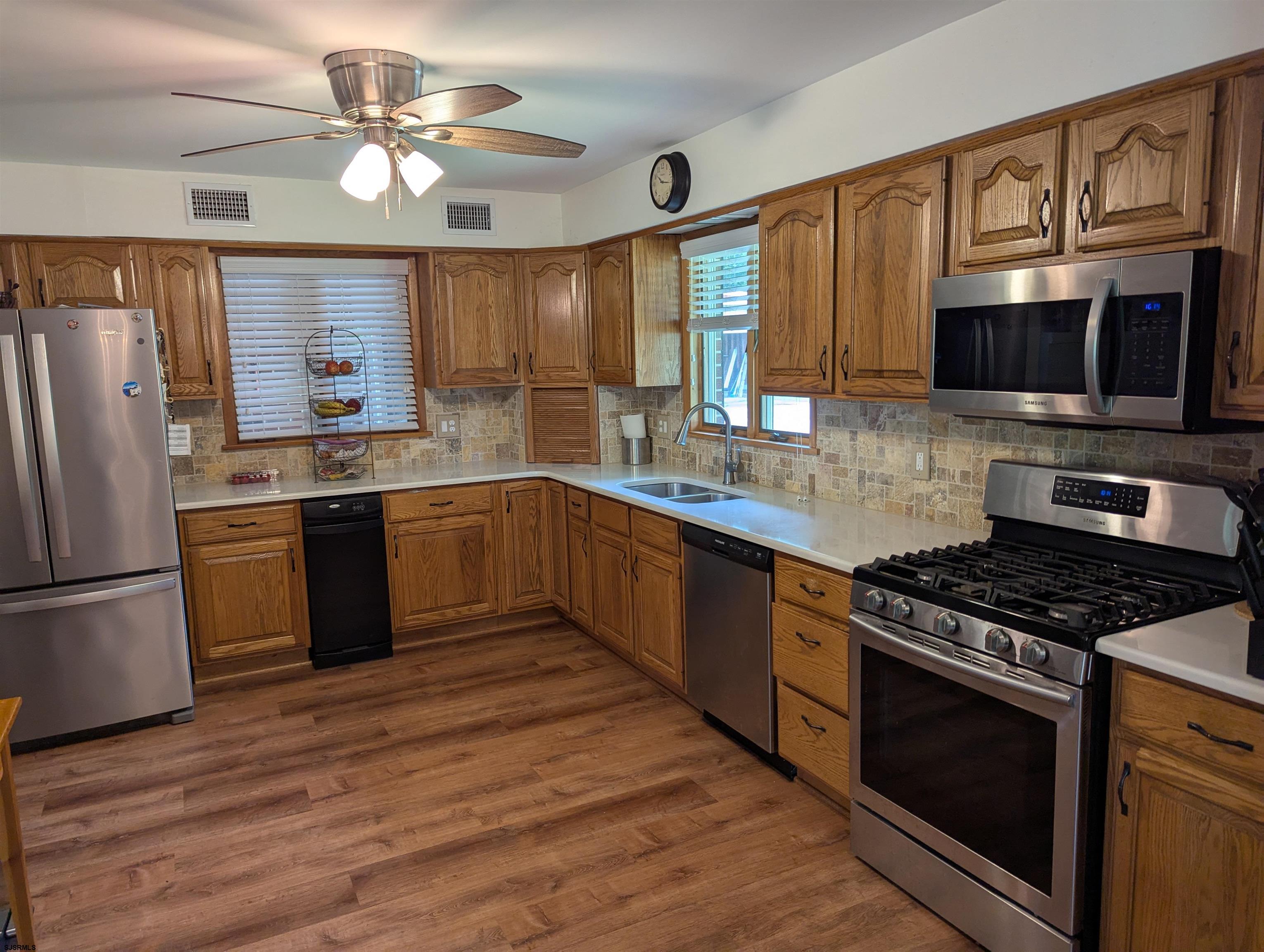 71 Perry Road Woodbine, NJ 08270 - Photo 5 of 32 a kitchen with stainless steel appliances granite countertop a stove top oven a sink dishwasher a refrigerator and a microwave oven on the wooden floor