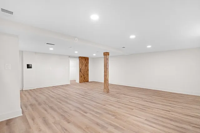 a view of an empty room with wooden floor