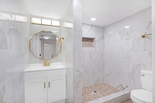 a bathroom with a toilet a sink and mirror