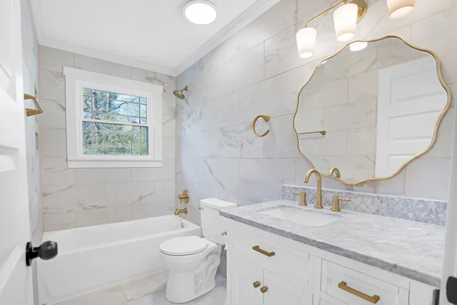 a bathroom with a granite countertop sink a toilet and bathtub