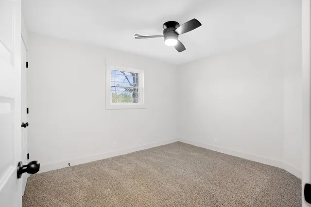 an empty room with a chandelier fan