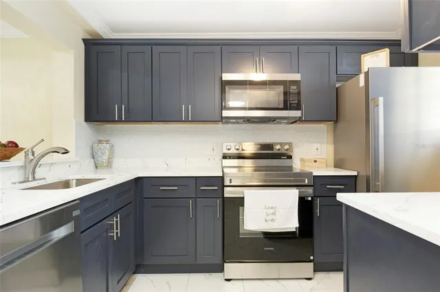 a kitchen with stainless steel appliances a stove microwave and refrigerator