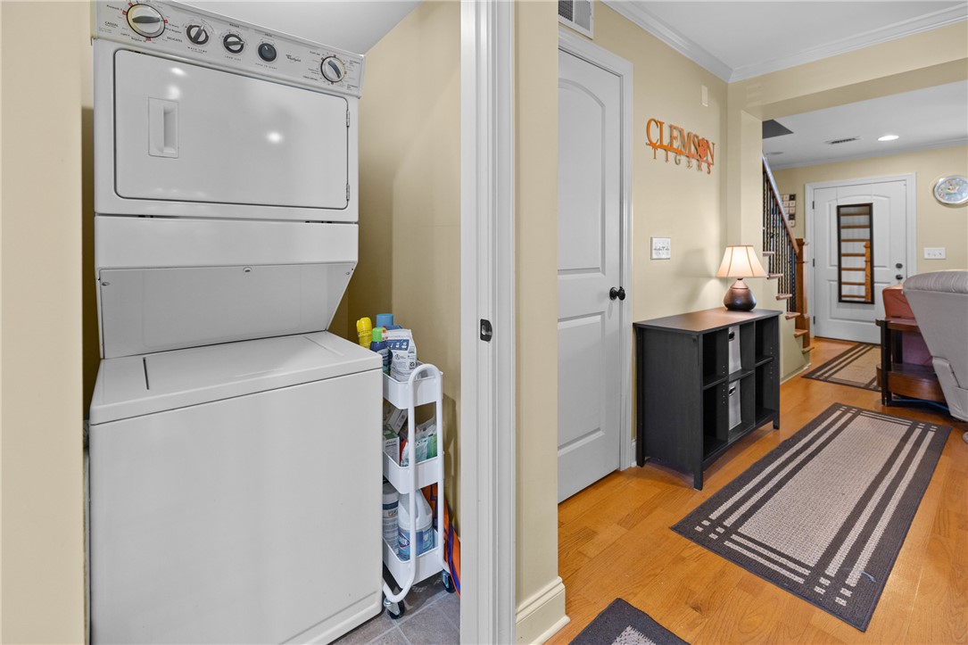 209 Calhoun Street, Unit 201 Clemson, SC 29631 - Photo 15 of 35 This functional space features convenient stacked laundry appliances, hardwood floors, and bright, inviting walls.