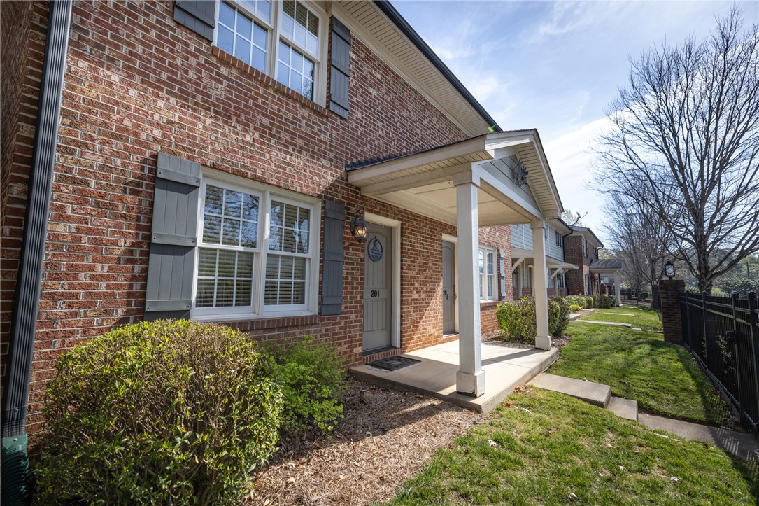 209 Calhoun Street, Unit 201 Clemson, SC 29631 - Photo 2 of 35 This charming brick exterior features inviting porches and well-maintained landscaping, offering a welcoming atmosphere.