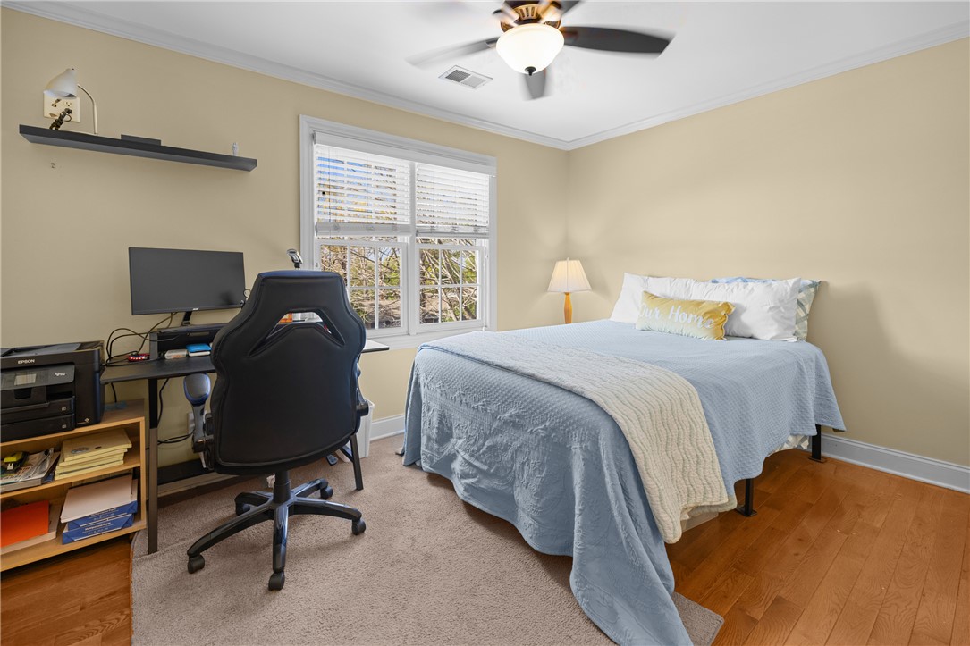 209 Calhoun Street, Unit 201 Clemson, SC 29631 - Photo 21 of 35 This inviting bedroom features natural light and rich hardwood flooring, creating a comfortable ambiance.