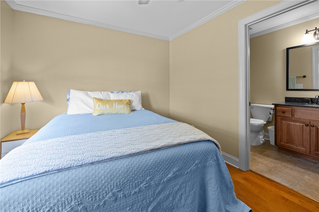 209 Calhoun Street, Unit 201 Clemson, SC 29631 - Photo 22 of 35 This cozy bedroom features warm wood flooring, crown molding, and an adjoining private bathroom.