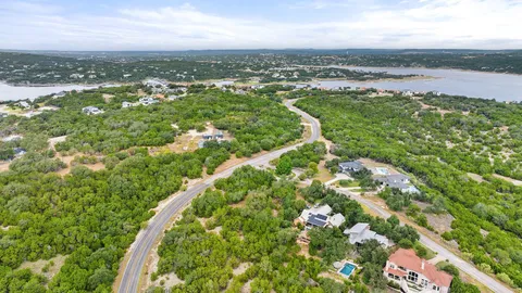 an aerial view of residential houses with outdoor space and trees