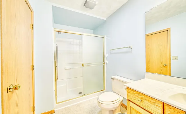 a bathroom with a granite countertop sink toilet and shower