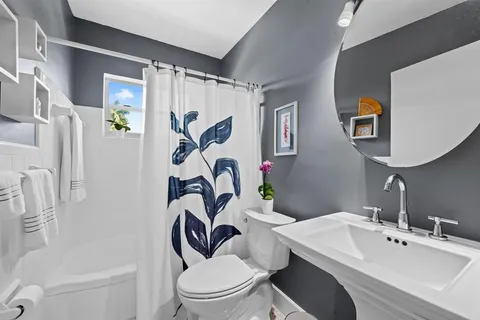 a bathroom with a toilet sink and mirror