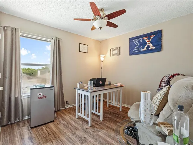 a view of a workspace with furniture and wooden floor