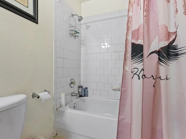 a bathroom with a bathtub a toilet and a shower