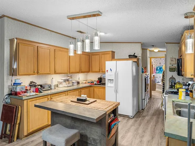 a kitchen with stainless steel appliances a refrigerator a sink a stove a refrigerator cabinets and wooden floor