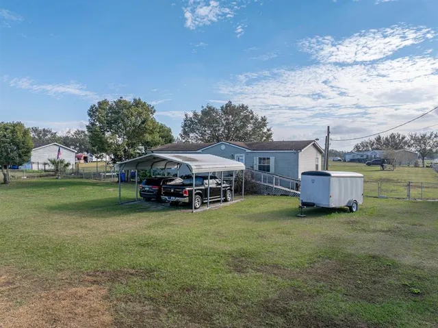 a view of house with backyard and outdoor seating