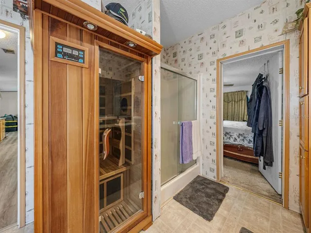 a view of a chair and tables in backyard of the house