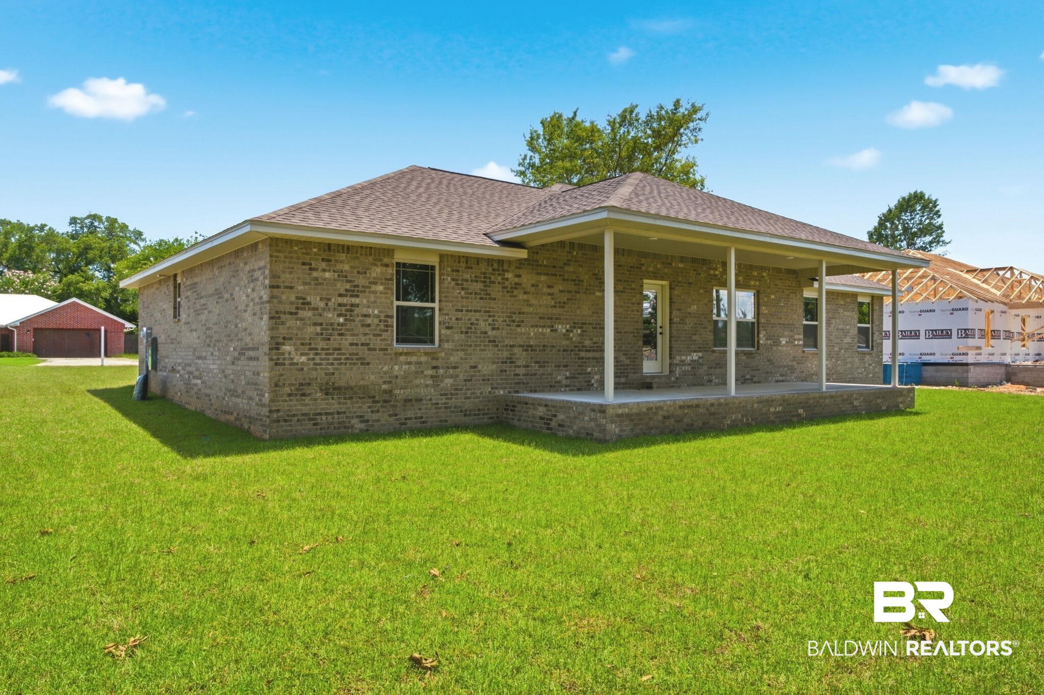 32656 Arbor Ridge Circle Lillian, AL 36549 - Photo 34 of 56 Brick exterior with a covered patio, multiple windows, and a shingle roof