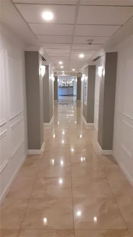 a view of a hallway with wooden floor and windows