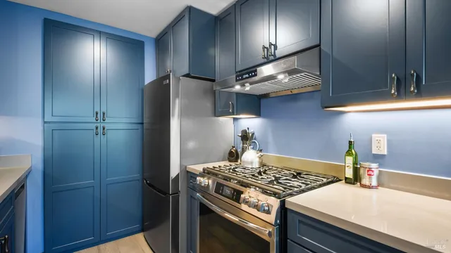a kitchen with stainless steel appliances granite countertop a stove and a refrigerator