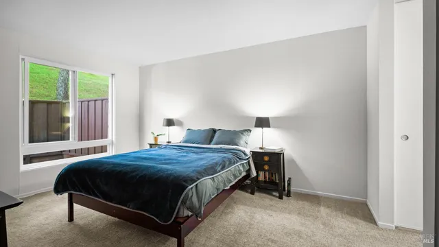 a bedroom with a bed lamp and window