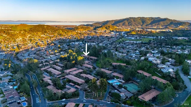 an aerial view of ocean and residential houses with outdoor space
