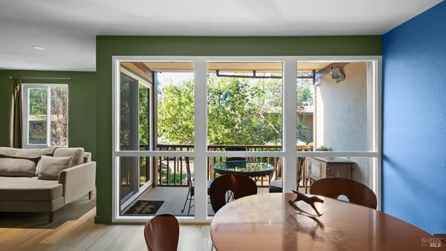 a living room with furniture a fireplace and large windows
