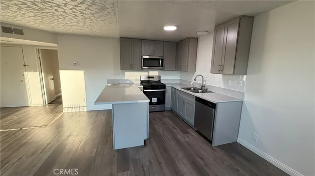 a kitchen with stainless steel appliances granite countertop wooden cabinets a stove top oven a sink and dishwasher