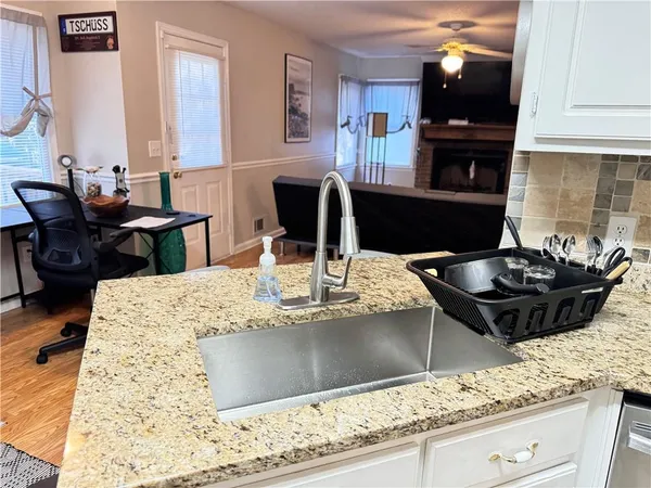 a kitchen with granite countertop a stove and white cabinets