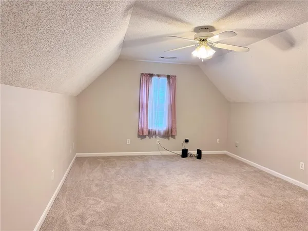 an empty room with a ceiling fan and a window