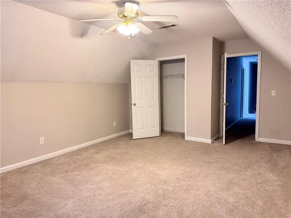 an empty room with a ceiling fan and a window