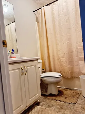 a bathroom with a toilet and a shower curtain