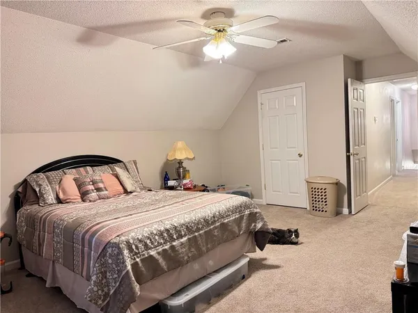 a spacious bedroom with a bed and a chandelier