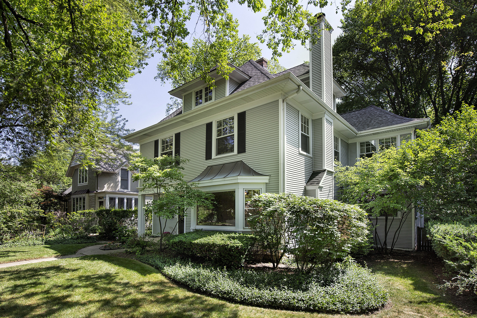 a front view of a house with a yard and potted plants