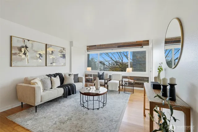 a living room with furniture a lamp next to a window and a flat screen tv