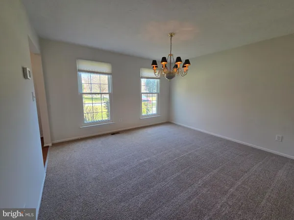 an empty room with windows and chandelier
