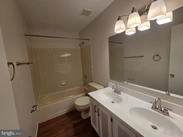 a bathroom with a sink a toilet a mirror and shower