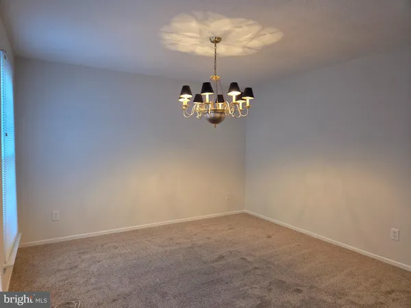 a room with a chandelier fan and a window