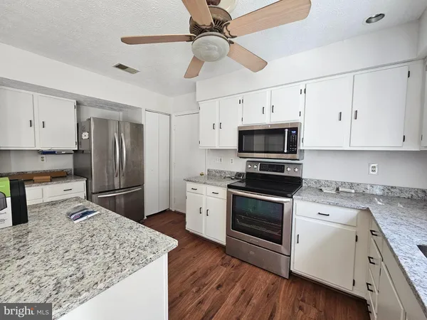 a kitchen with stainless steel appliances granite countertop a stove oven and a refrigerator