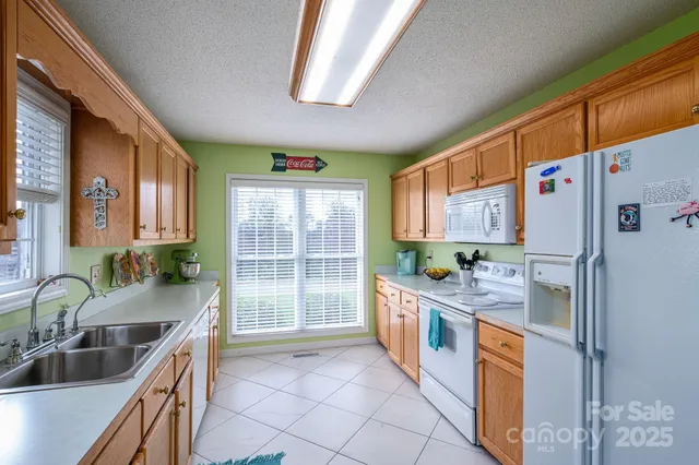 a kitchen with stainless steel appliances granite countertop a sink and a refrigerator