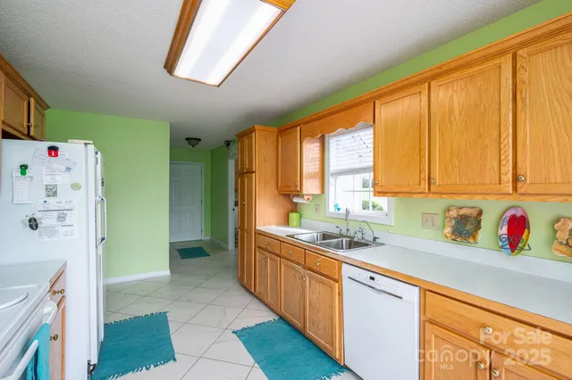 a kitchen with stainless steel appliances a sink a refrigerator and a window