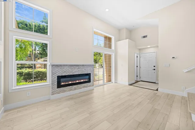 a view of an empty room with a fireplace and a window