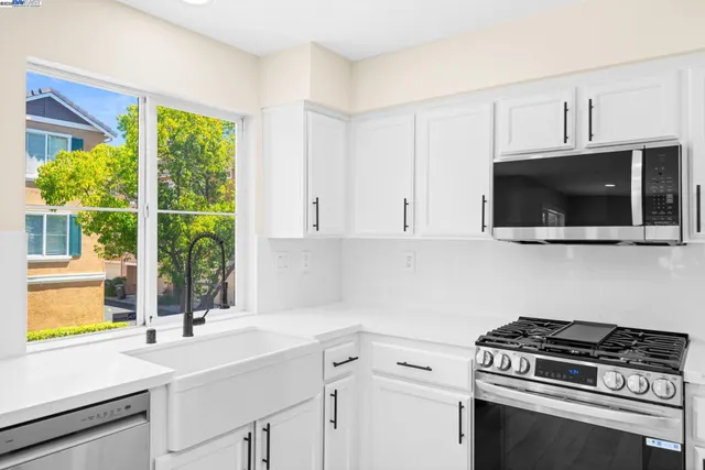 a kitchen with a sink a stove and a microwave